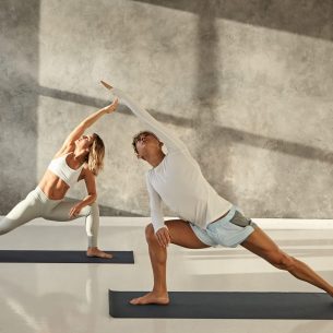 young-couple-practicing-yoga-together-indoor-picture-handsome-tanned-guy-mat-doing-standing-pose-s-strengthen-legs-stretching-arms-looking-up (1)